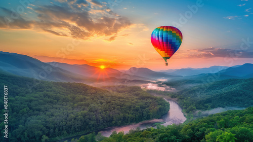 Colorful hot air balloon flying over green valley with road and mountain background at sunrise  bucket list lifestyle concept