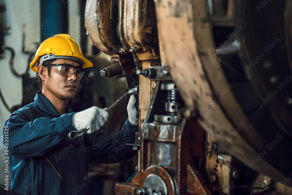 Asian engineer mechanic man checking and using wrench for maintenance pressing metal machine at factory, worker at industrial working Asian engineer mechanic man checking and using wrench for maintenance pressing metal machine at factory, worker at industrial working