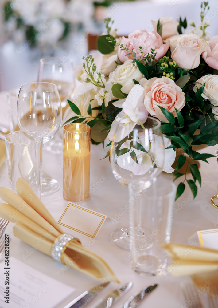 Dining table with beautiful table settings and floral decorations. Beautifully decorated table in a restaurant. Silver cutlery, fresh flowers and clear glasses decorate the table in a restaurant Dining table with beautiful table settings and floral decorations. Beautifully decorated table in a restaurant. Silver cutlery, fresh flowers and clear glasses decorate the table in a restaurant