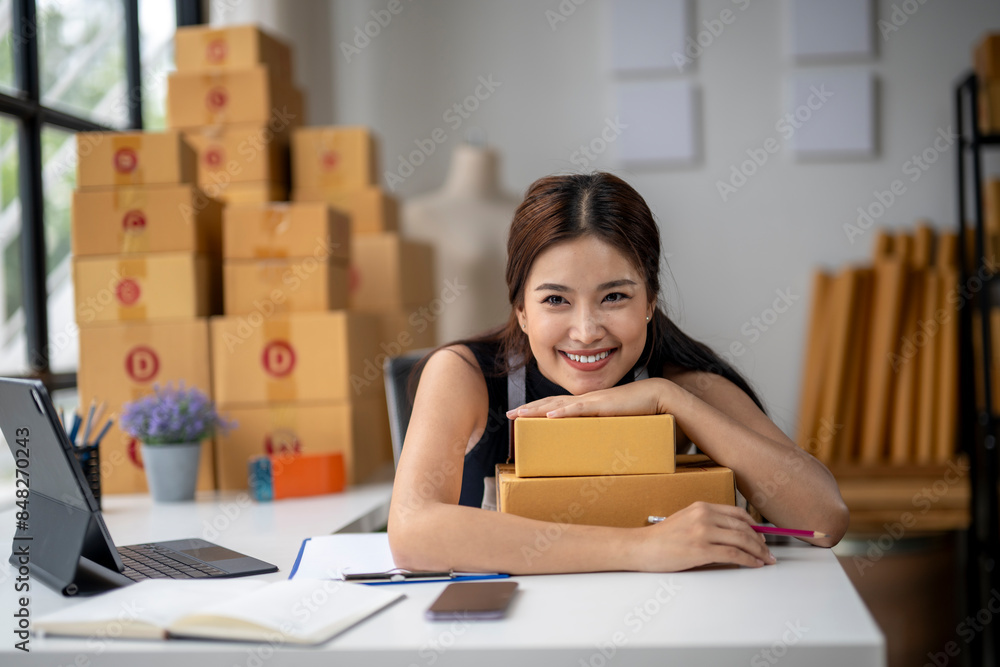 A woman is sitting at a desk with a laptop and a stack of boxes A woman is sitting at a desk with a laptop and a stack of boxes