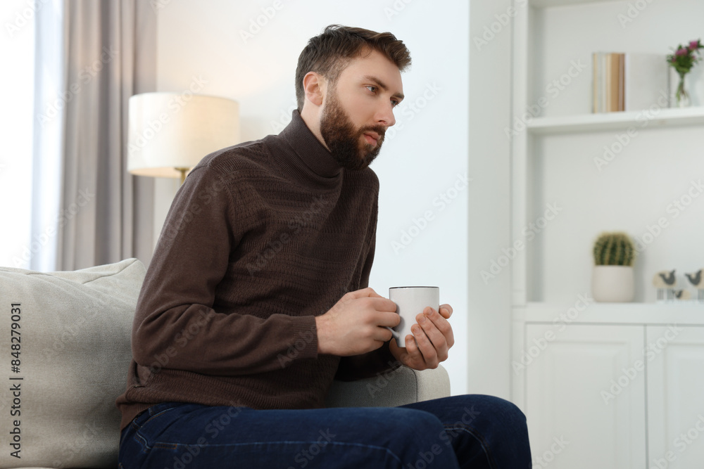Loneliness concept. Sad man sitting on sofa at home Loneliness concept. Sad man sitting on sofa at home