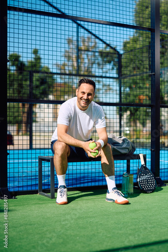 Portrait of happy paddle tennis player looking at camera.