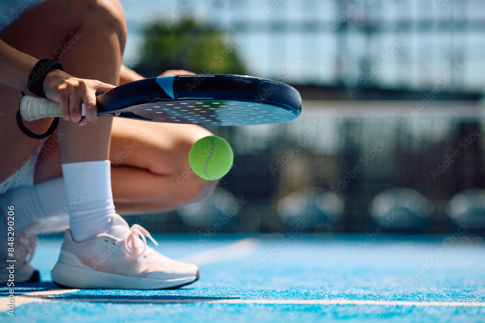 Fototapeta premium Close up of female paddle tennis player practicing on outdoor court.