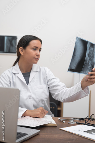 Patient Care: In the provision of healthcare services, a doctor utilizes a radiological X-ray film to care for the patient by diagnosing their illness. photo