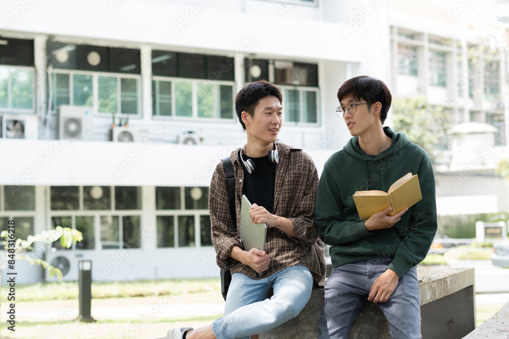 Young University Students Engaging in Conversation Outdoors, Holding Books and Smiling, Campus Background, Friendship and Education Concept Young University Students Engaging in Conversation Outdoors, Holding Books and Smiling, Campus Background, Friendship and Education Concept