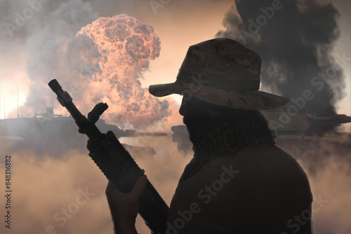 A military soldier with a machine gun against the background of burning tanks, fire and smoke. Concept: war in the Middle East, 