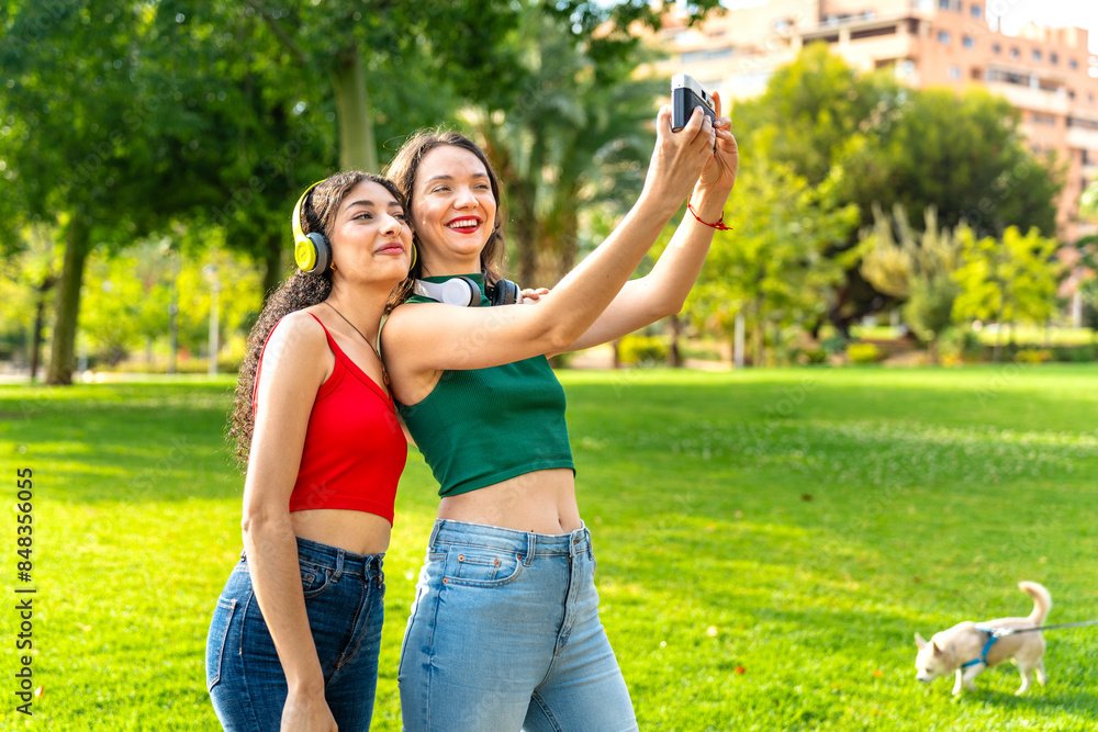 Obraz premium Young girls share laughter and capture memories with a vintage camera