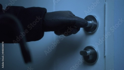 Close-up of the house's door unlocked by a male robber wearing black gloves, home security to prevent the crimination, criminal impact on economic society.
 photo