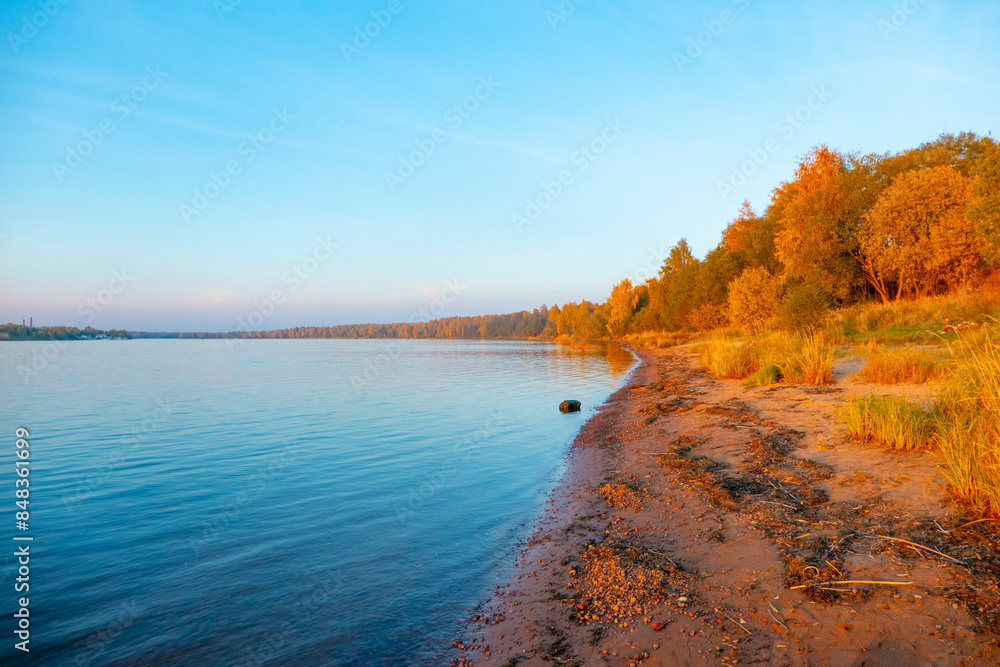 Colorful autumn landscape with birch grove with golden foliage on the shore of the lake and beautiful reflections at sunset. High quality photo