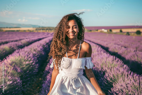 Woman smiles brightly, walking in vibrant lavender field