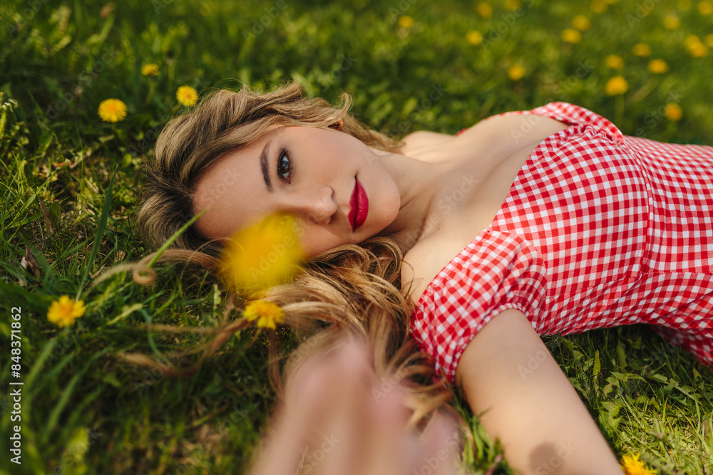 Young woman lying in a grassy field with flowers Young woman lying in a grassy field with flowers