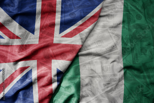 Canvas-taulu big waving colorful flag of nigeria and national flag of great britain on the dollar money background