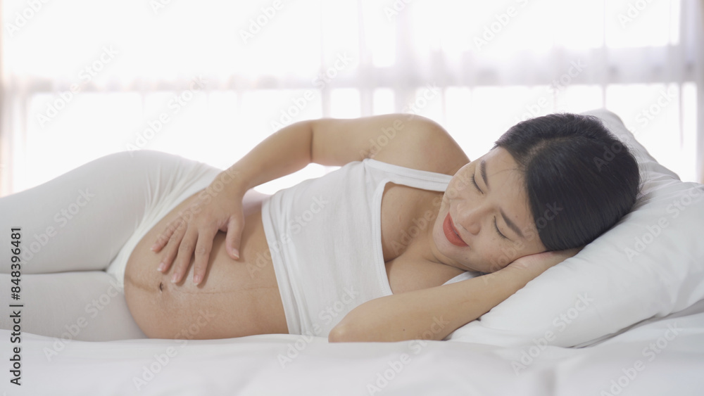 A Portrait of happy Asian pregnant woman in bedroom at home. Having a baby. Family people lifestyle. Love. A Portrait of happy Asian pregnant woman in bedroom at home. Having a baby. Family people lifestyle. Love.
