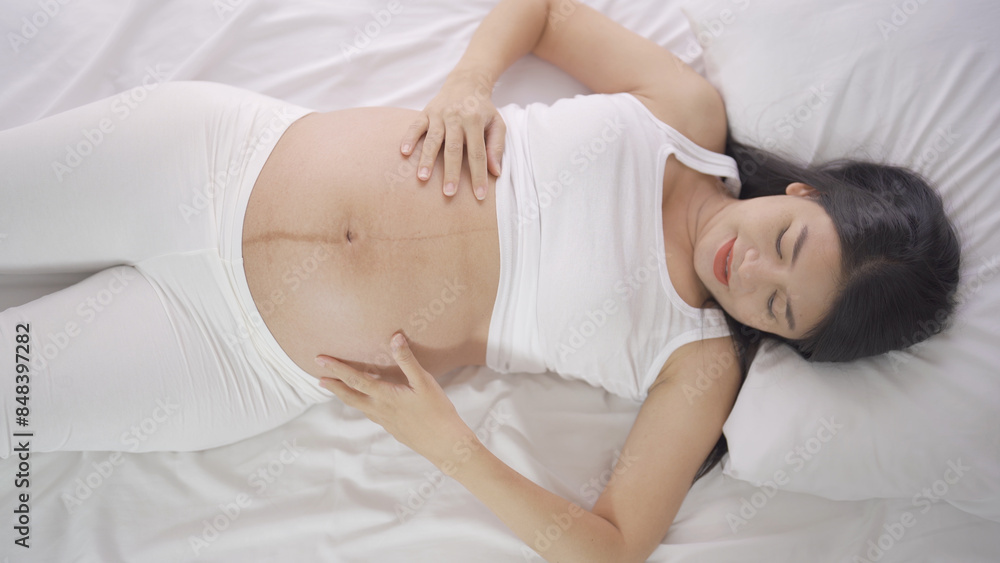 A Portrait of happy Asian pregnant woman in bedroom at home. Having a baby. Family people lifestyle. Love. A Portrait of happy Asian pregnant woman in bedroom at home. Having a baby. Family people lifestyle. Love.