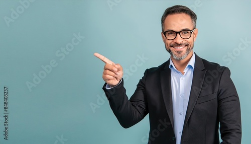 Middle-aged businessman pointing finger isolated on light blue background with copy space