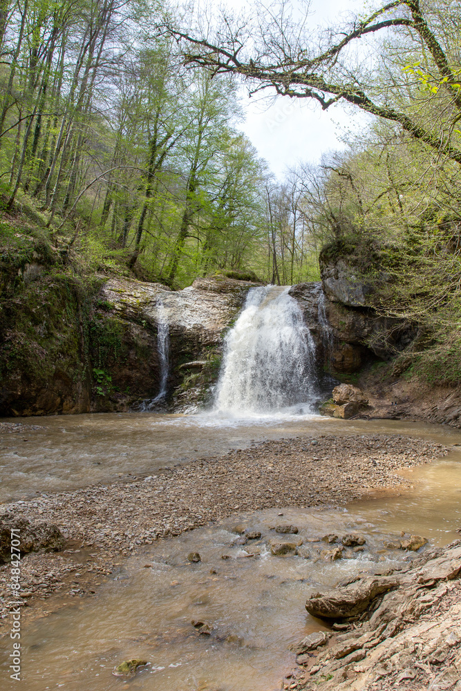Obraz premium the beginning of summer mountains, waterfall, the sources of the mountain river walking along the canyon , hiking trails and recreation in the mountains.