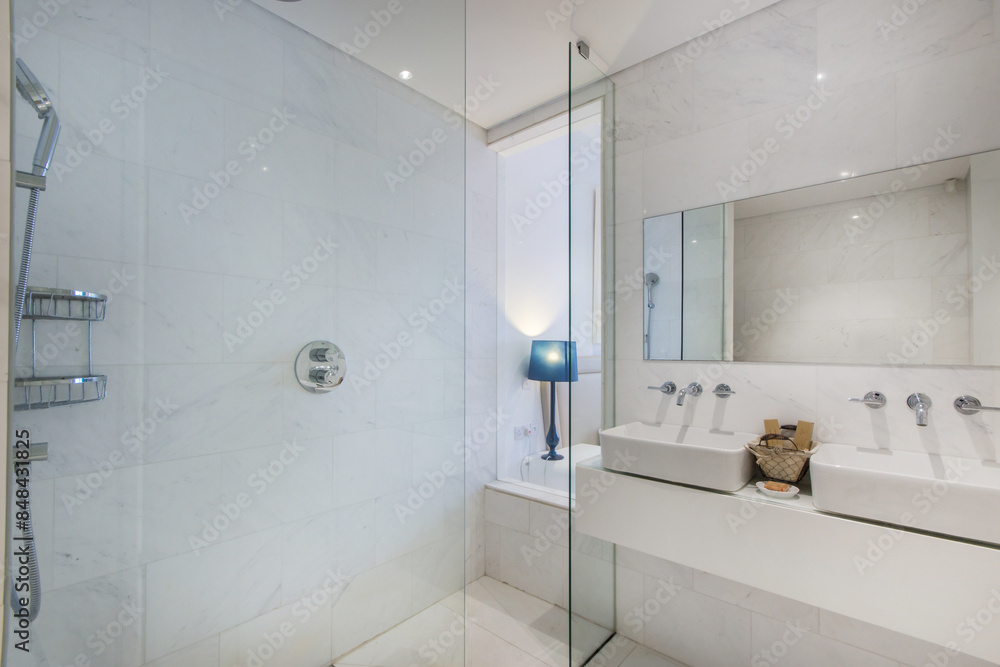 Shower cabin in the hotel bathroom with white tile trim. Two sinks and a large mirror above them.. Shower cabin in the hotel bathroom with white tile trim. Two sinks and a large mirror above them..