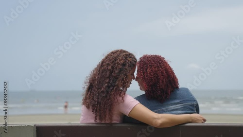 Sweet and tender between two multiracial women in love shown of affection in public. Free love to all sexual orientation. Lesbian young relationship.
 photo