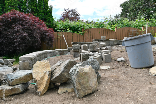 Yard and garden project in progress, bricks and rocks for terracing sloped outdoor space © Kristin