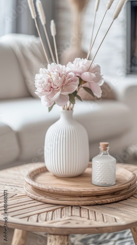 Fototapeta Naklejka Na Ścianę i Meble -  Stylish home decor with a vase of beautiful pink peonies and a different style coffee table in the living room.