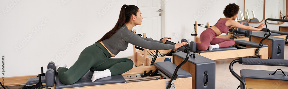 Alluring woman is intensively exercising next to her friend. Alluring woman is intensively exercising next to her friend.