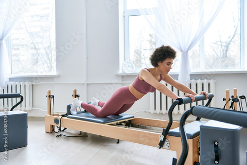 A woman in a pink top works out, pilates. © LIGHTFIELD STUDIOS