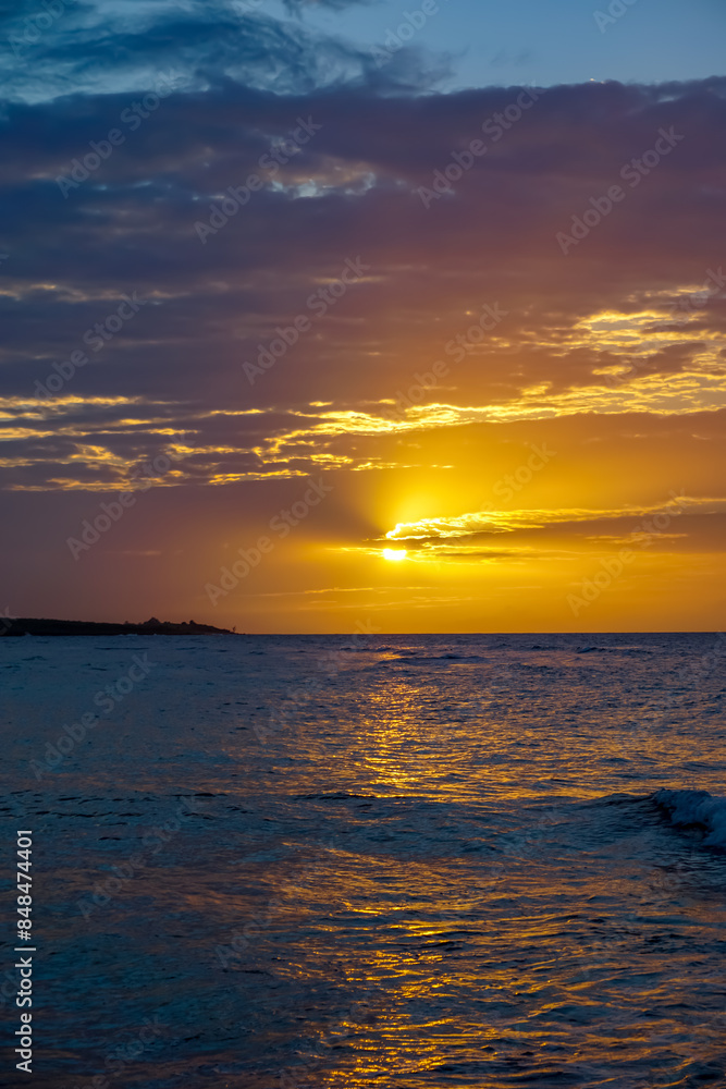 Fototapeta premium Sunsets in Jamaica are a stunning display of vibrant colors over serene beaches. From Negril's cliffs to Montego Bay's shores, enjoy breathtaking views, romantic settings.