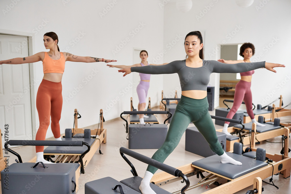 A group of pretty sporty women gracefully practicing pilates in a class. A group of pretty sporty women gracefully practicing pilates in a class.