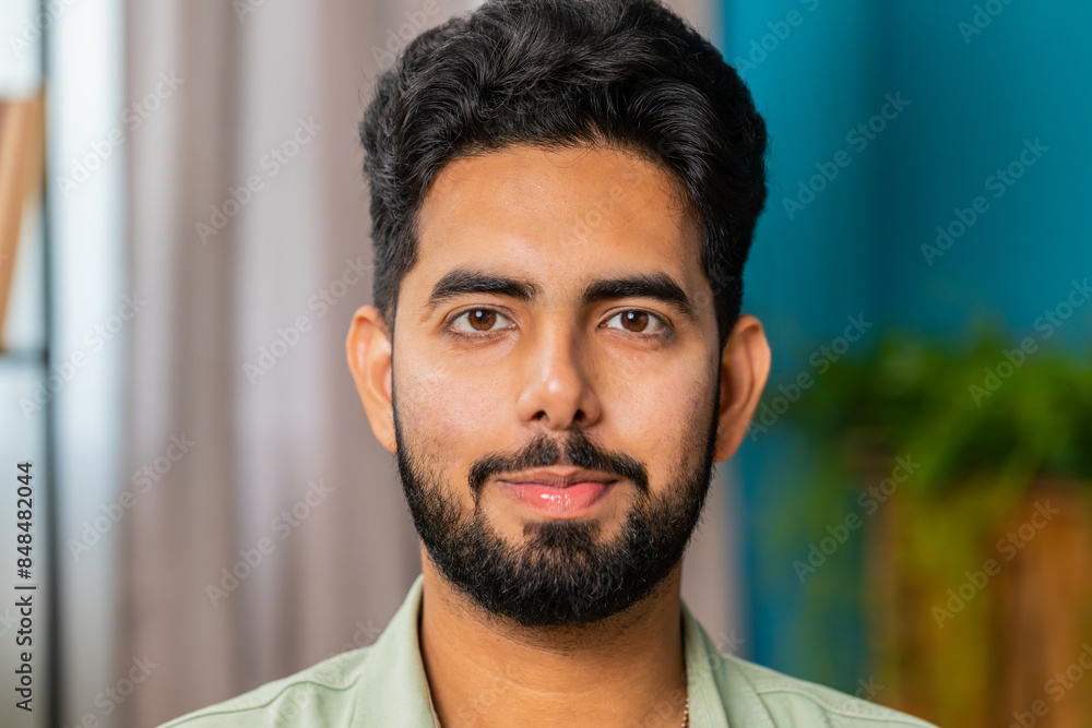 Portrait of happy calm Indian man at home couch smiling friendly, glad expression looking away dreaming resting, relaxation feel satisfied good news, celebrate win. Arabian young guy in living room Portrait of happy calm Indian man at home couch smiling friendly, glad expression looking away dreaming resting, relaxation feel satisfied good news, celebrate win. Arabian young guy in living room