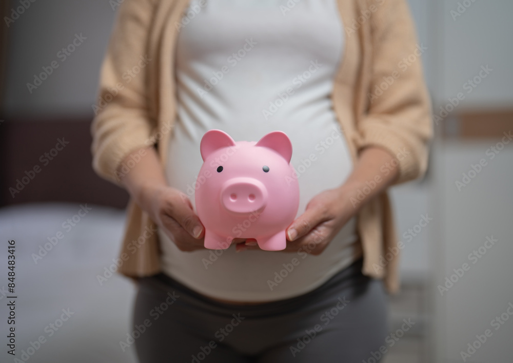 A portrait of happy Asian pregnant woman save financial money for baby with piggy bank in bedroom at home. Having a baby. Family people lifestyle. Mom love. A portrait of happy Asian pregnant woman save financial money for baby with piggy bank in bedroom at home. Having a baby. Family people lifestyle. Mom love.