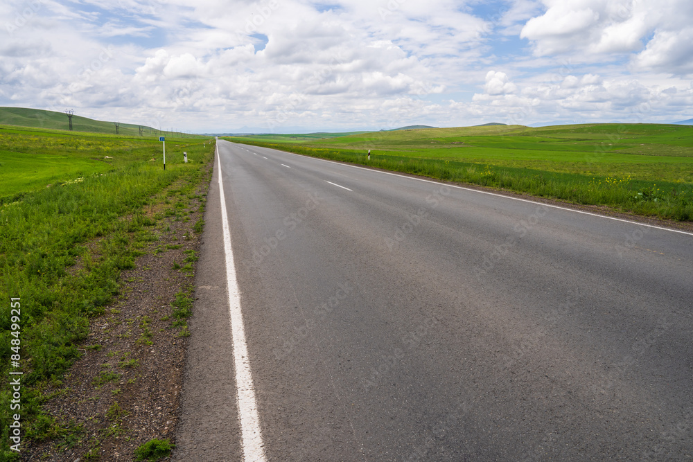 Asphalt road, grassy sidewalks, travel concept Asphalt road, grassy sidewalks, travel concept