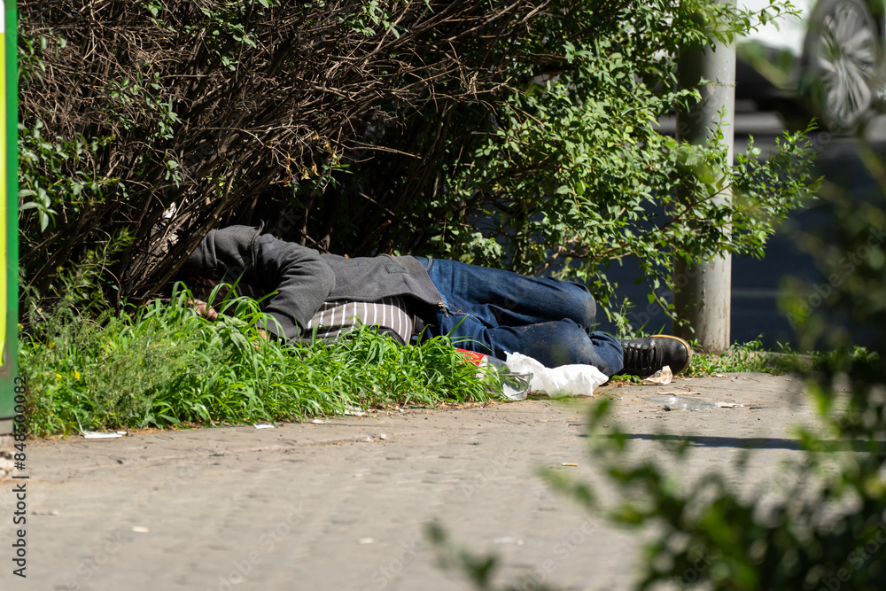 An alcoholic beggar is sleeping on the ground An alcoholic beggar is sleeping on the ground