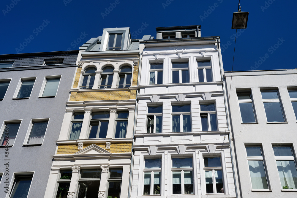 Fototapeta premium beautifully restored and decorated narrow old town houses flanked by unadorned facades in the Friesenviertel district of Cologne
