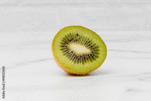 Kiwi Half on White Countertop and White Brick Background