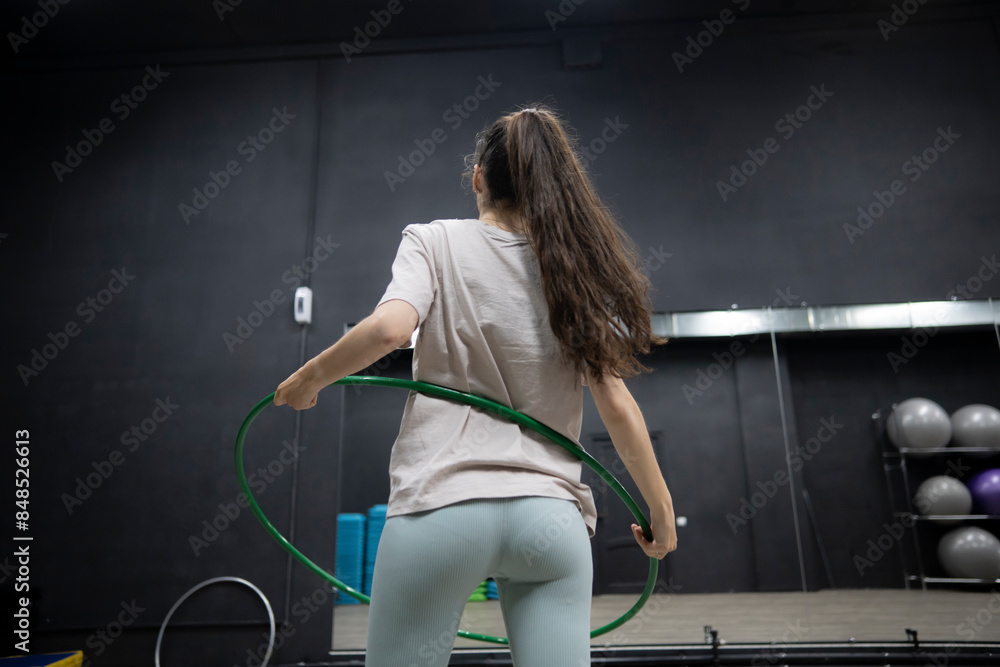 Young Girl Exercising With a Hoop Ring in a Dark Fitness Studio Young Girl Exercising With a Hoop Ring in a Dark Fitness Studio