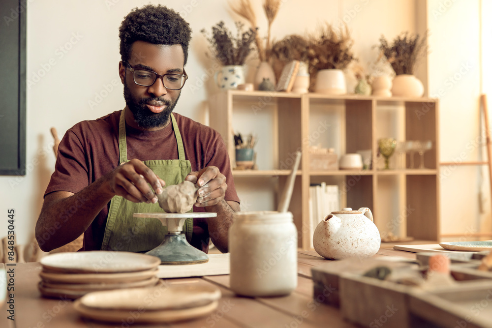 African american young man working with clay in pottery studio African american young man working with clay in pottery studio