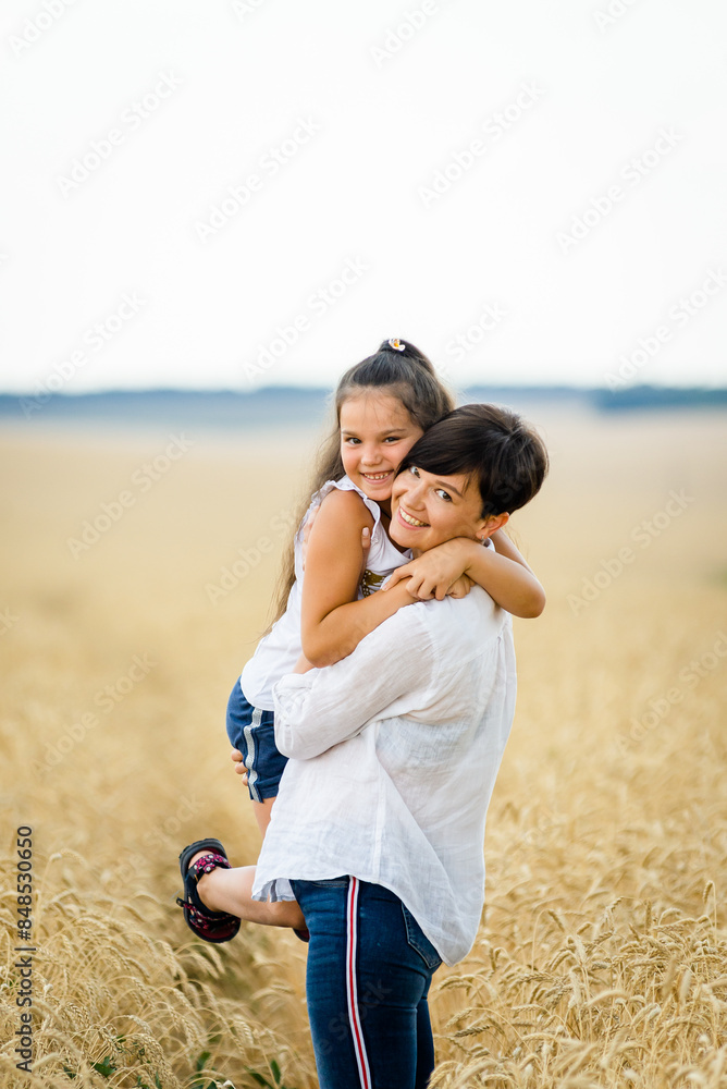 World food crisis. Deficit of grain in the world markets. Mom and daughter are walking in a wheat field. World food crisis. Deficit of grain in the world markets. Mom and daughter are walking in a wheat field.