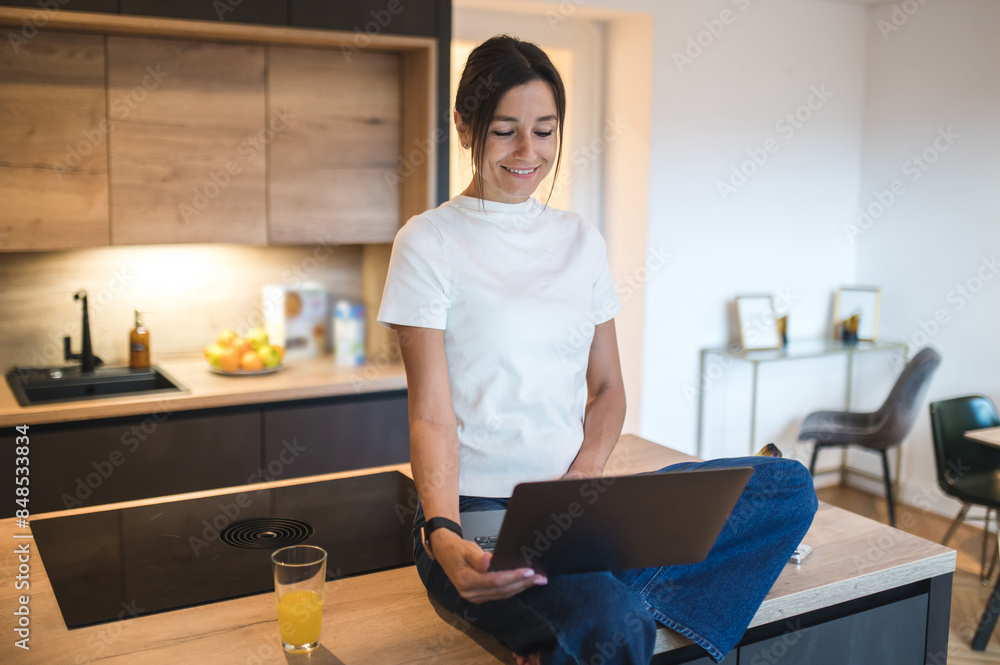 Dark-haired caucasian woman having a video call and looking contented Dark-haired caucasian woman having a video call and looking contented