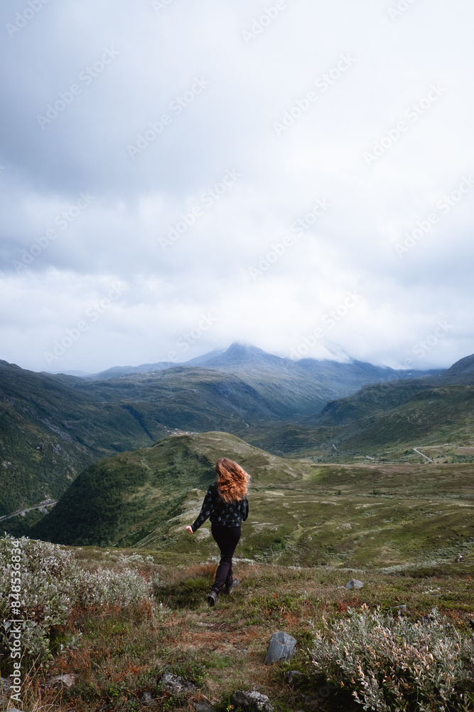Eine Frau mit roten haaren rennt durch die Berge Eine Frau mit roten haaren rennt durch die Berge