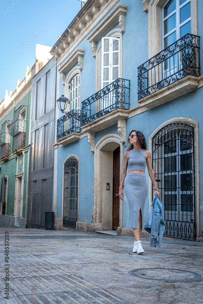 Young Woman in Grey Dress on Marble Street in Almeria Young Woman in Grey Dress on Marble Street in Almeria
