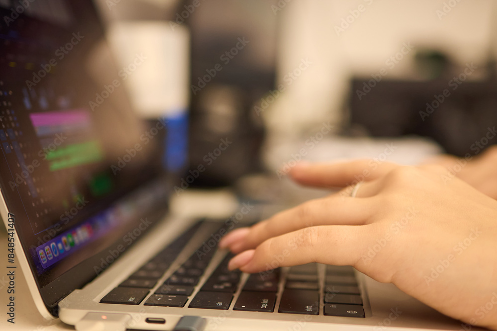 A closeup showing hands typing on a laptop keyboard, with an engagement ring on the finger A closeup showing hands typing on a laptop keyboard, with an engagement ring on the finger