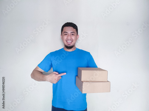 Adult Asian man smiling happy while delivering a package cardbox photo