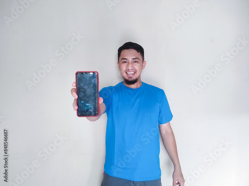 Asian mature man smiling confidently while holding blank mobile phone screen photo