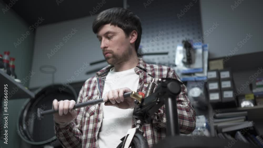 Male mechanical engineer, repairman repairs mechanical damage to wheel of children scooter. Small business for service and maintenance of ecological transport of scooters. Broken kick e scooter. Male mechanical engineer, repairman repairs mechanical damage to wheel of children scooter. Small business for service and maintenance of ecological transport of scooters. Broken kick e scooter.