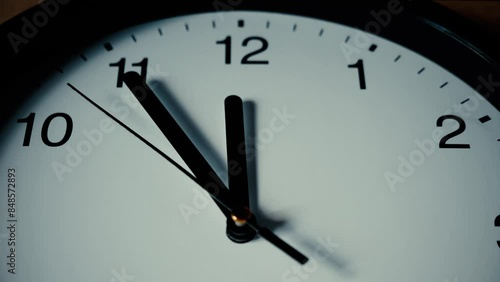 Clock dial. Second arrow hand moves towards 12. Time is 5 minutes to midnight. Passage of time. Concept of time passing, procrastination, steady movement forward. Creative plot. Shallow depth of field