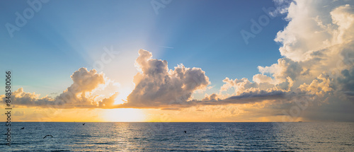 Sea sunset with cloudy sky and sun through the clouds over. Clouds Ocean and sky background, seascape.