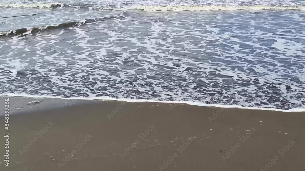 The atmosphere of the waves crashing on the beach, during a sunny day The atmosphere of the waves crashing on the beach, during a sunny day
