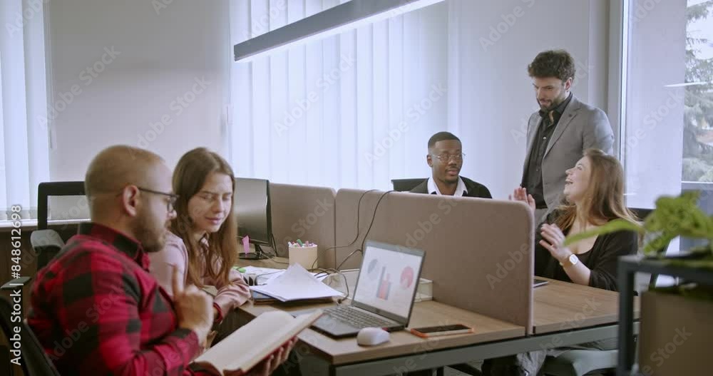 Team of multiracial professionals collaborating in open office workspace. Team of multiracial professionals collaborating in open office workspace.