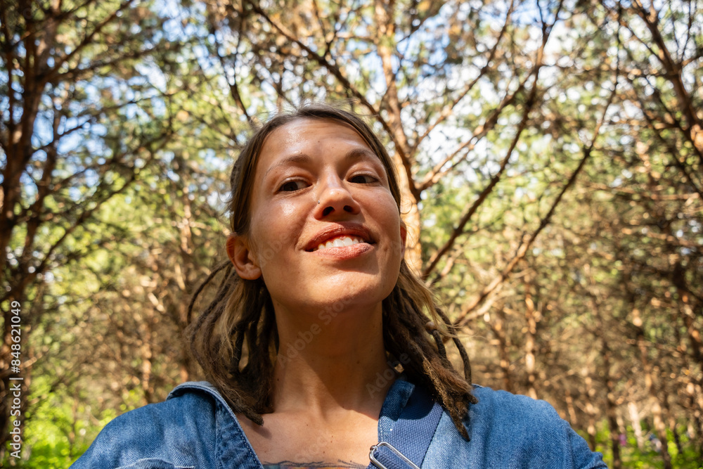 Smiling woman in the summery pine forest.