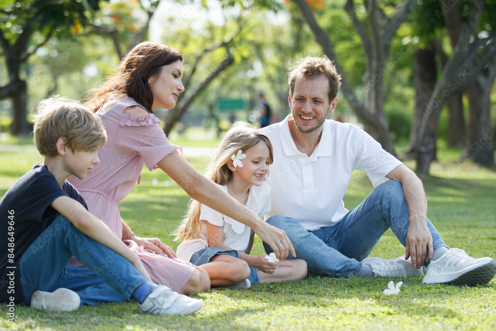 Caucasian family parent and their children picnic at the park in morning. Caucasian family parent and their children picnic at the park in morning.